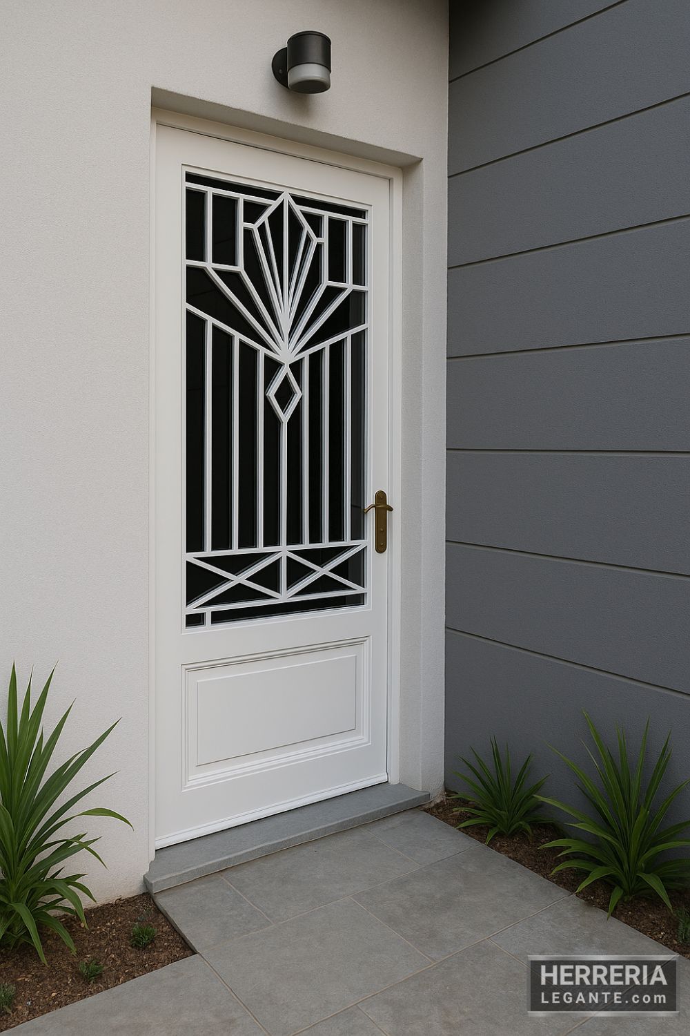 puerta de herrería blanca con diseño geométrico y vidrio oscuro, en fachada contemporánea gris con piso de piedra y plantas decorativas, vista en ángulo de tres cuartos