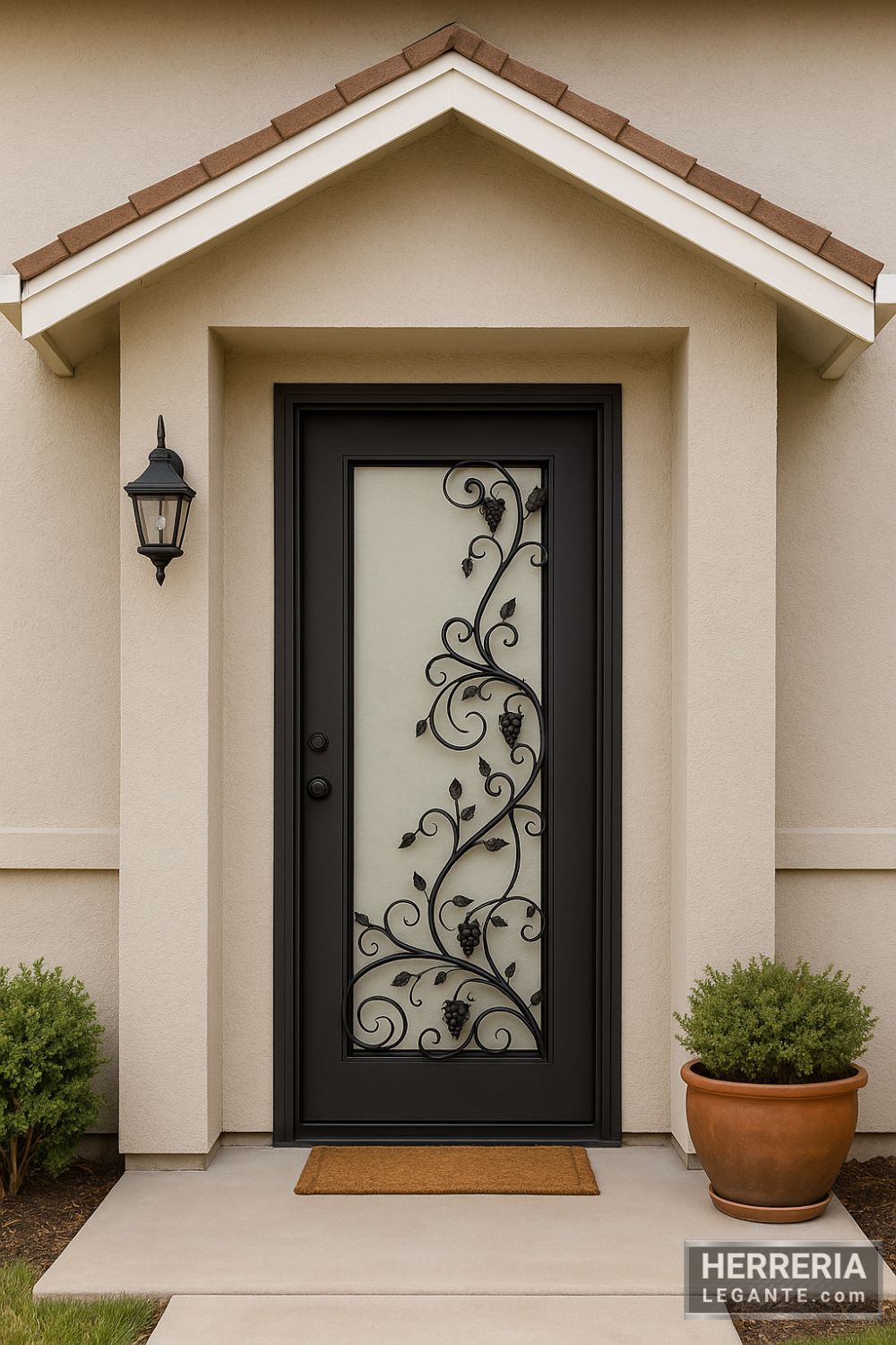 Puerta de herrería negra con vidrio esmerilado y diseño de enredadera, instalada en entrada principal de casa pequeña con fachada en tono claro