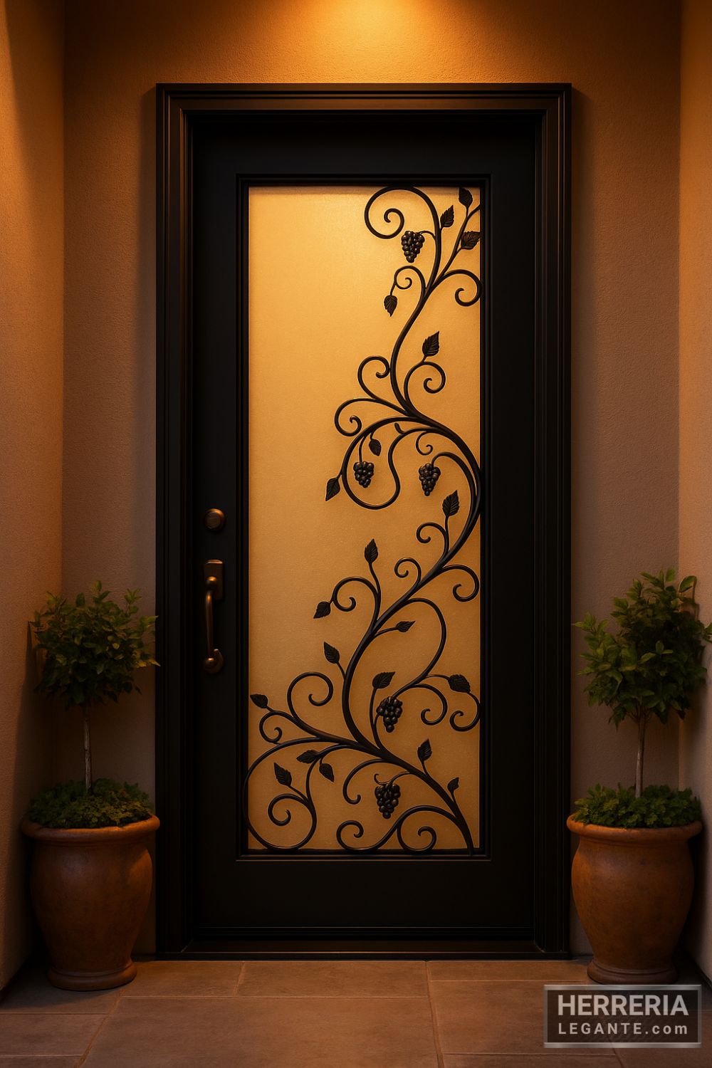 Puerta de herrería negra con vidrio esmerilado y diseño de enredadera iluminada con luz cálida en entrada residencial