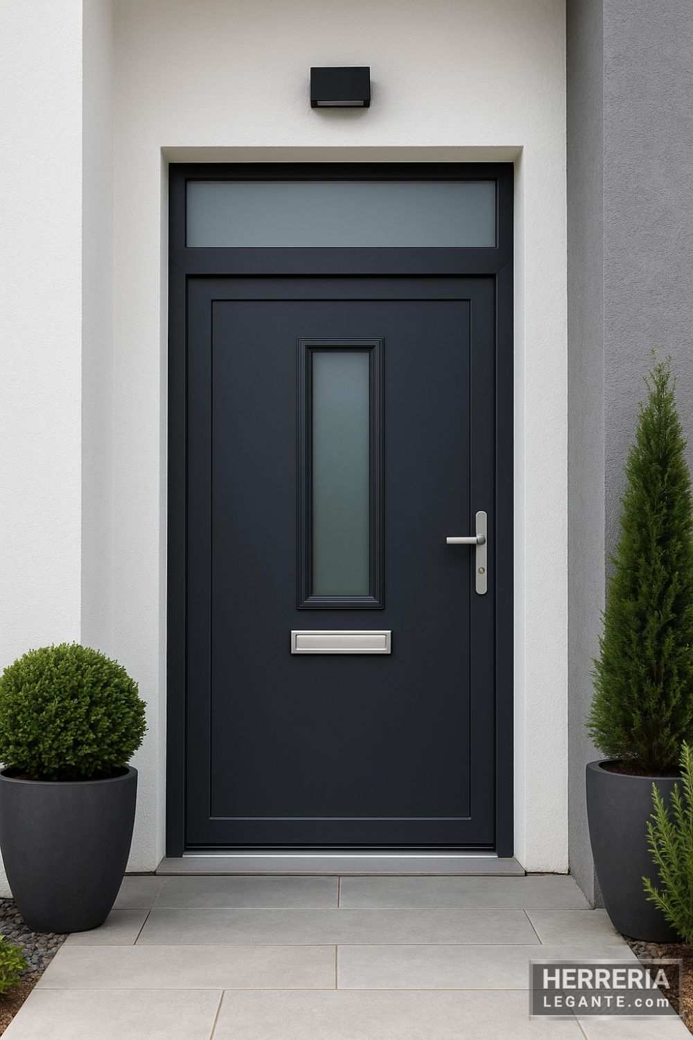 puerta de herrería grafito con vidrio alargado central, en fachada minimalista blanca y gris con piso de loseta clara y plantas decorativas