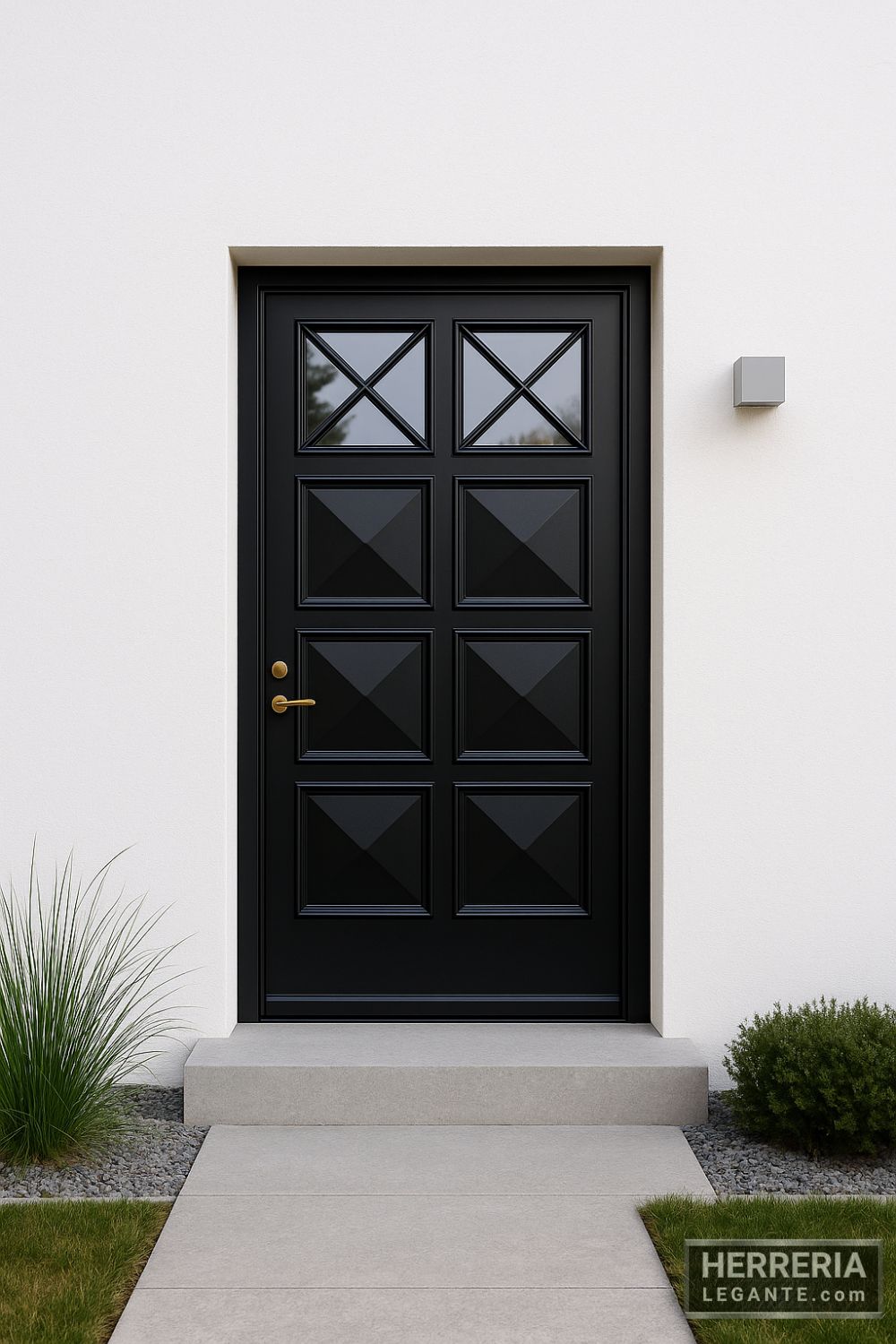 puerta de herrería negra con paneles geométricos y ventanillas en aspa, en fachada minimalista de estuco blanco con jardín discreto